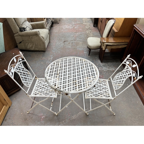 180 - A white painted metal circular folding patio table and two chairs - approx. 75cm high x 70cm diamete... 