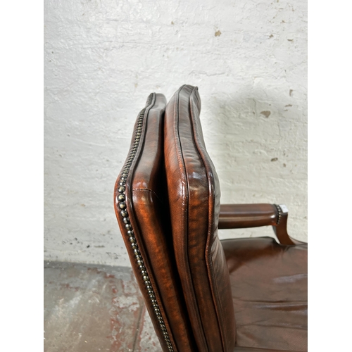 25 - A Bevan Funnell Reprodux brown leather and mahogany swivel office desk chair