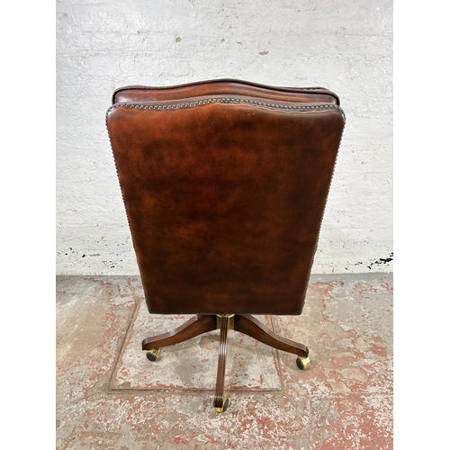 30 - A Bevan Funnell Reprodux brown leather and mahogany swivel office desk chair