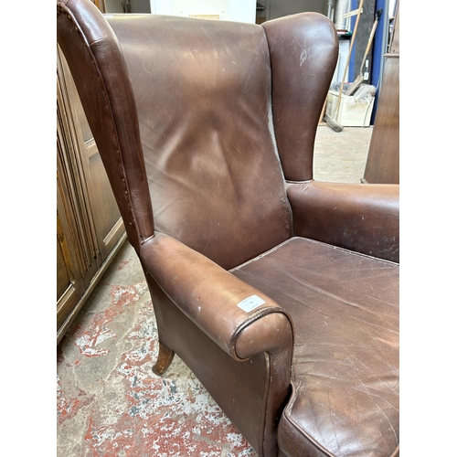 59 - A brown leather wingback armchair on cabriole supports