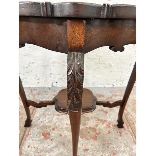 64 - A late Victorian carved mahogany two tier occasional table - approx. 73cm high x 68cm diameter