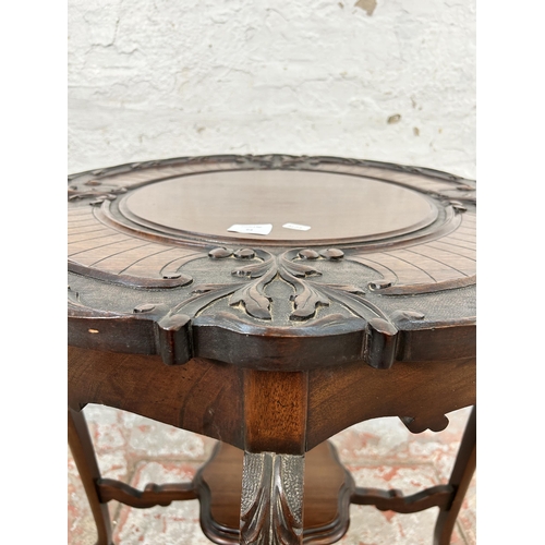 64 - A late Victorian carved mahogany two tier occasional table - approx. 73cm high x 68cm diameter