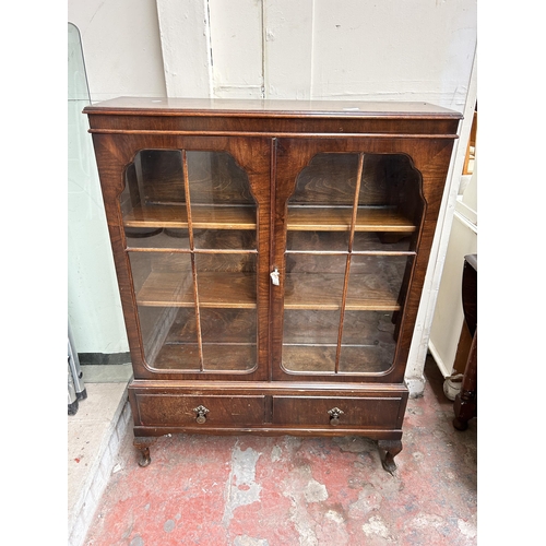 67 - An early/mid 20th century walnut display cabinet with two glazed doors and cabriole supports - appro... 