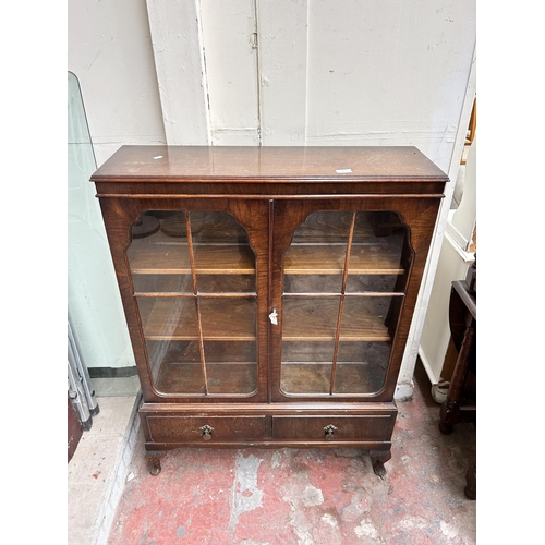 67 - An early/mid 20th century walnut display cabinet with two glazed doors and cabriole supports - appro... 