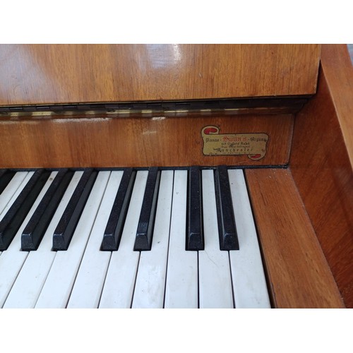 780 - A walnut Bentley upright piano with height adjustable stool and sheet music