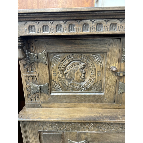 200 - A 17th century style carved oak court cupboard - approx. 152cm high x 147cm wide x 42cm deep