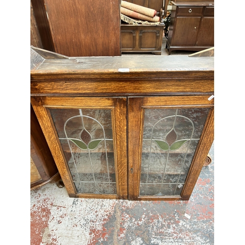 217 - An early 20th century oak bookcase with two leaded and stained glass doors - approx. 100cm high x 96... 