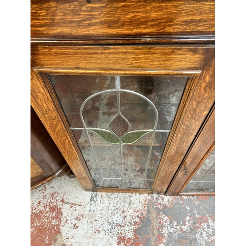 217 - An early 20th century oak bookcase with two leaded and stained glass doors - approx. 100cm high x 96... 