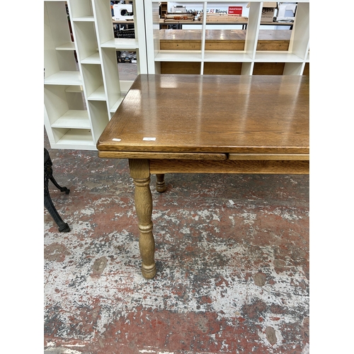 227 - An oak rectangular extending dining table - approx. 75cm high x 90cm wide x 145cm long