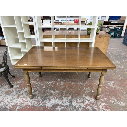 227 - An oak rectangular extending dining table - approx. 75cm high x 90cm wide x 145cm long