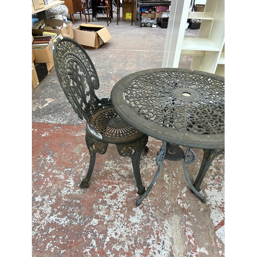 228 - A Victorian style grey painted cast metal circular patio table and two chairs - approx. 66cm high x ... 