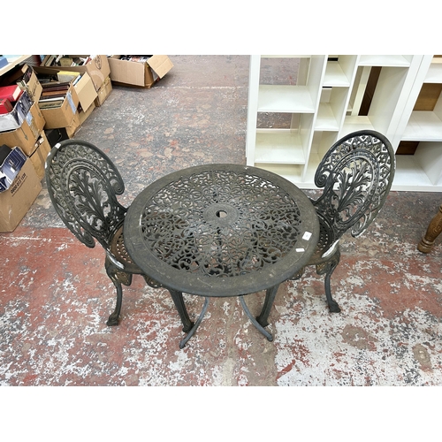 228 - A Victorian style grey painted cast metal circular patio table and two chairs - approx. 66cm high x ... 