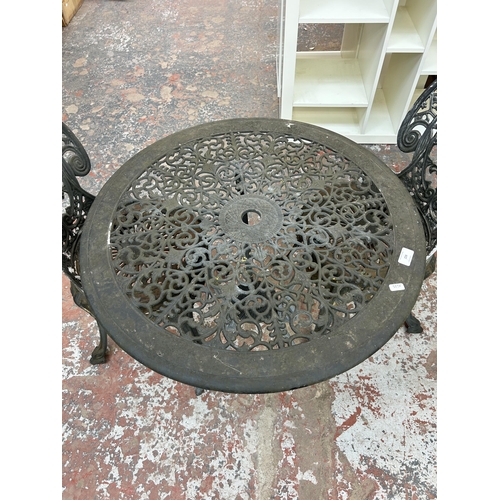 228 - A Victorian style grey painted cast metal circular patio table and two chairs - approx. 66cm high x ... 