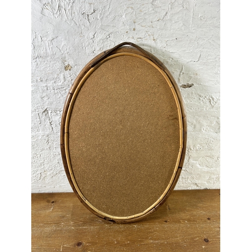 253 - A mid 20th century bamboo framed oval wall mirror - approx. 60cm high x 42cm wide