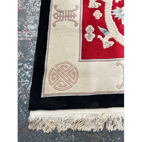 129 - A Chinese dragon pattern rug - approx. 280cm x 183cm