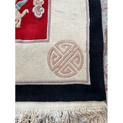 129 - A Chinese dragon pattern rug - approx. 280cm x 183cm