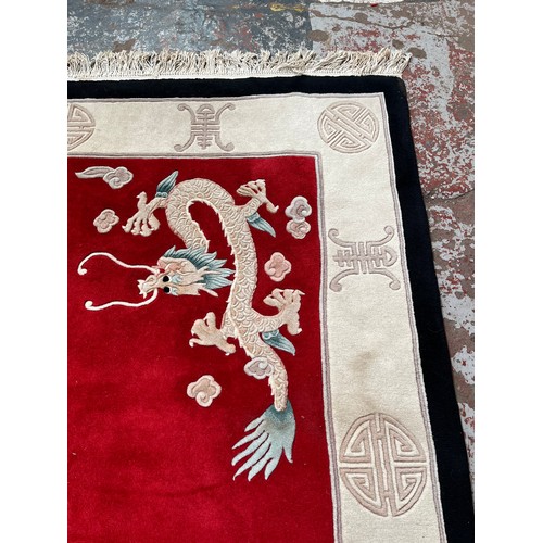 129 - A Chinese dragon pattern rug - approx. 280cm x 183cm