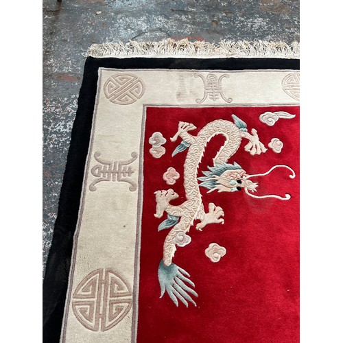 129 - A Chinese dragon pattern rug - approx. 280cm x 183cm