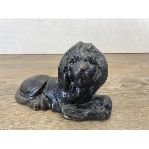 419 - A pair of cast iron and black painted doorstops in the form of lions