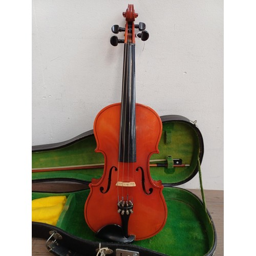 793 - A cased Hsinghai full size violin with bow, shoulder rest and rosin