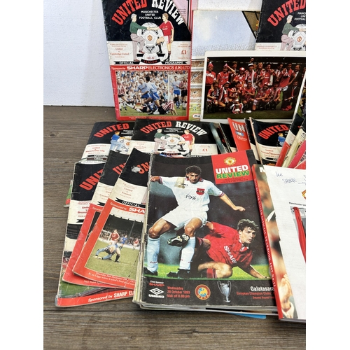 572 - A collection of 1990s Manchester United official programmes together with a signed official year boo... 