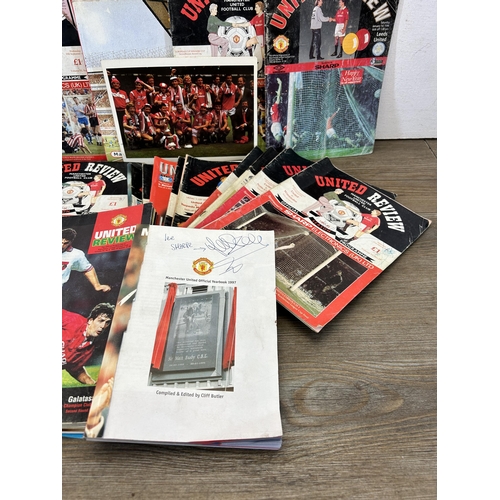 572 - A collection of 1990s Manchester United official programmes together with a signed official year boo... 