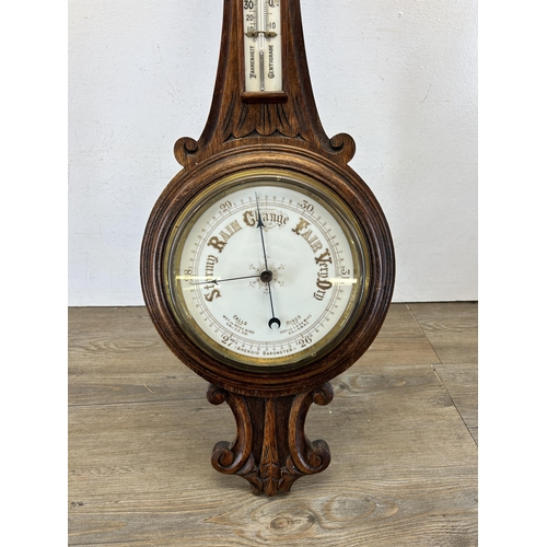 621 - A 19th century carved oak aneroid barometer - approx. 88cm high