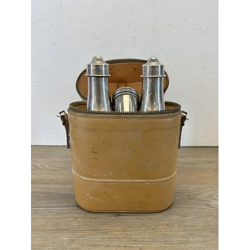 660 - A vintage leather cased travel drinking set containing two cognac and whisky bottles and four shot c... 