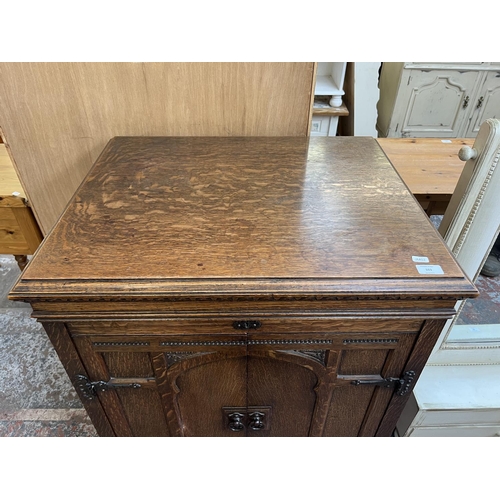 103 - An early 20th century carved oak two door gramophone cabinet - approx. 104cm high x 72cm wide x 59cm... 