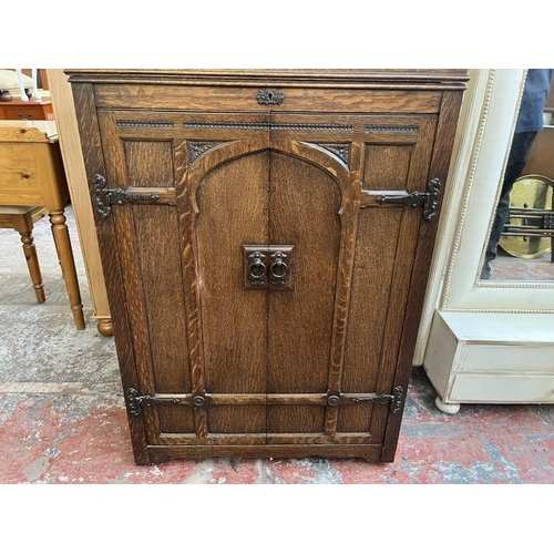 103 - An early 20th century carved oak two door gramophone cabinet - approx. 104cm high x 72cm wide x 59cm... 