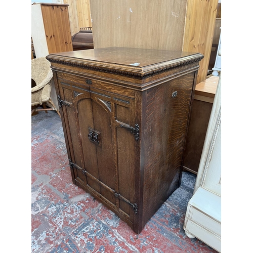 103 - An early 20th century carved oak two door gramophone cabinet - approx. 104cm high x 72cm wide x 59cm... 