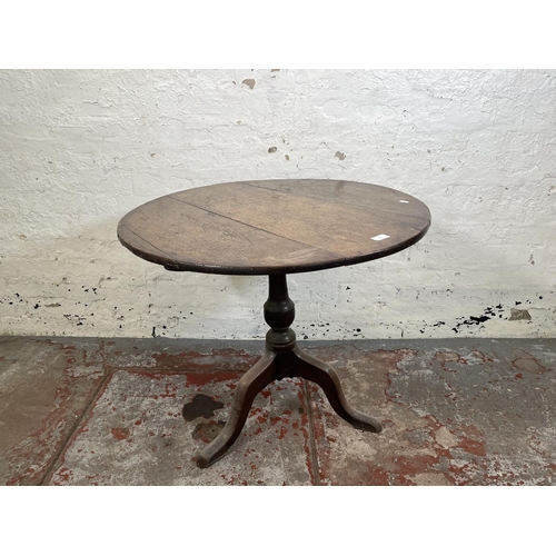 104 - A George III oak circular tilt top tripod occasional table - approx. 69cm high x 78cm diameter