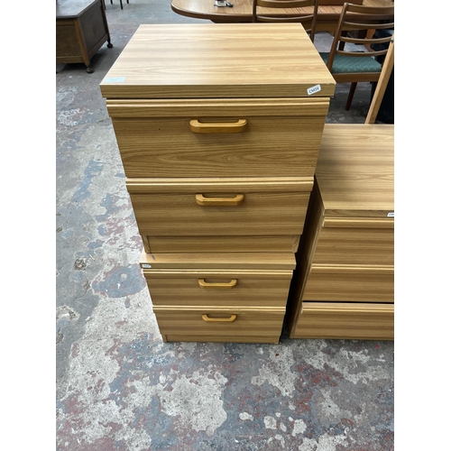 114 - A late 20th century oak effect four piece bedroom suite comprising two bedside chests of drawers and... 