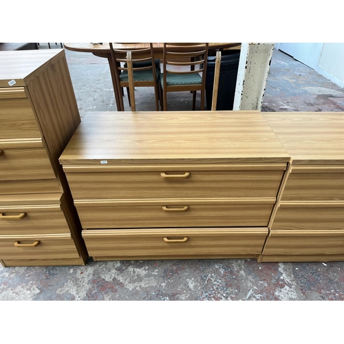 114 - A late 20th century oak effect four piece bedroom suite comprising two bedside chests of drawers and... 