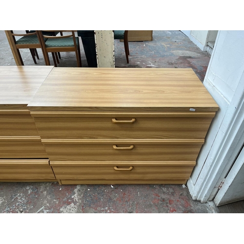 114 - A late 20th century oak effect four piece bedroom suite comprising two bedside chests of drawers and... 