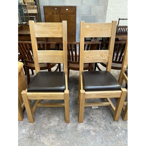 23 - Four modern oak and brown leatherette dining chairs