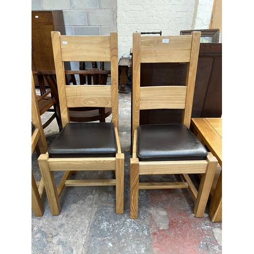 23 - Four modern oak and brown leatherette dining chairs