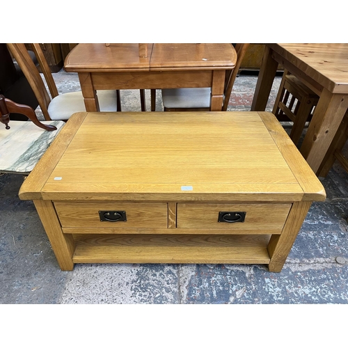 26 - A modern solid oak rectangular two drawer coffee table - approx. 50cm high x 65cm wide x 105cm long