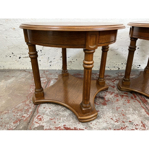 29 - A pair of oak circular two tier side tables - approx. 51cm high x 60cm diameter