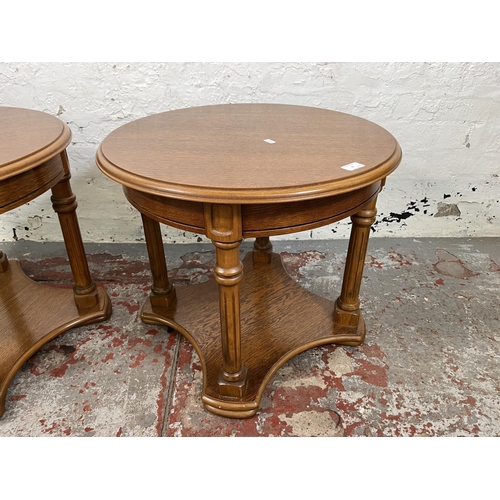 29 - A pair of oak circular two tier side tables - approx. 51cm high x 60cm diameter