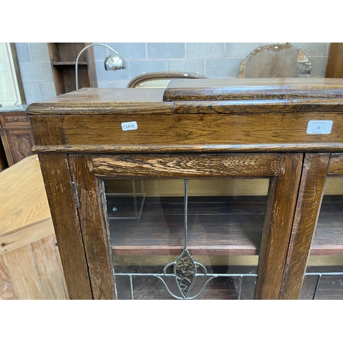 33 - An early 20th century oak and lead glazed two door bookcase - approx. 128cm high x 92cm wide x 26cm ... 