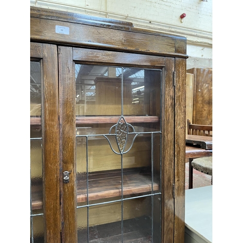 33 - An early 20th century oak and lead glazed two door bookcase - approx. 128cm high x 92cm wide x 26cm ... 