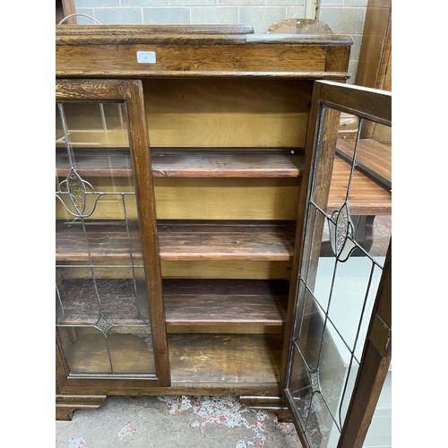 33 - An early 20th century oak and lead glazed two door bookcase - approx. 128cm high x 92cm wide x 26cm ... 