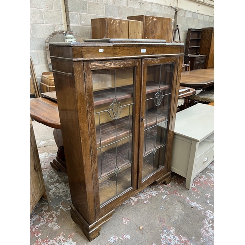 33 - An early 20th century oak and lead glazed two door bookcase - approx. 128cm high x 92cm wide x 26cm ... 