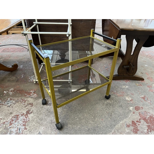 35 - Two pieces of 1970s furniture, one gilt metal and smoked glass two tier tea trolley and one white pl... 