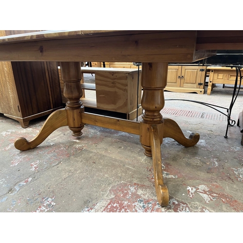 36 - A pine twin pedestal extending dining table - approx. 76cm high x 100cm wide x 180cm long