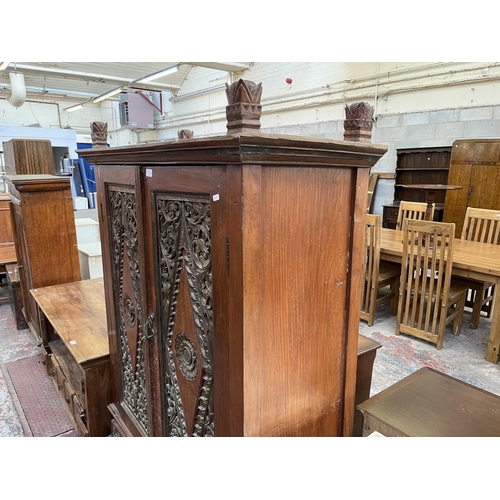 49 - An Indonesian carved teak two door cabinet - approx. 166cm high x 114cm wide x 49cm deep