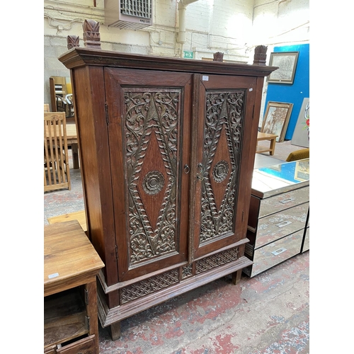 49 - An Indonesian carved teak two door cabinet - approx. 166cm high x 114cm wide x 49cm deep