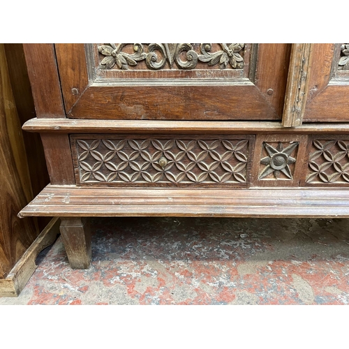 49 - An Indonesian carved teak two door cabinet - approx. 166cm high x 114cm wide x 49cm deep