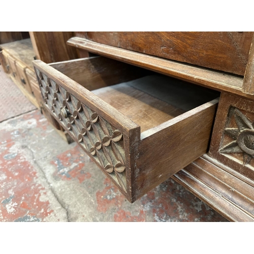 49 - An Indonesian carved teak two door cabinet - approx. 166cm high x 114cm wide x 49cm deep